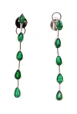 une paire de boucles d'oreilles avec des pierres vertes sur fond blanc