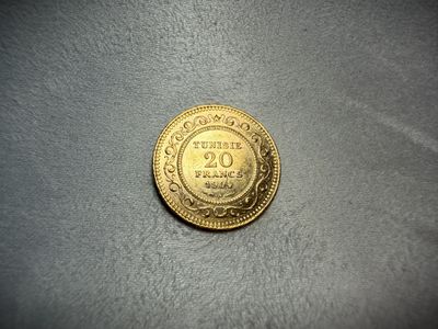a close up of a gold coin on a gray surface