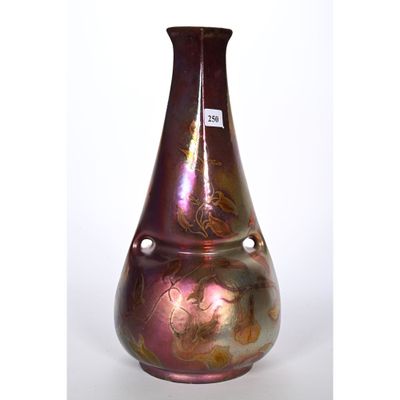 un vase violet orné de motifs dorés sur fond blanc