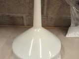 a white toilet brush sitting on a counter next to a bag of toilet paper