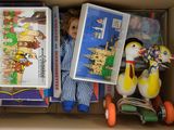 une boîte remplie de jouets, avec une poupée dedans