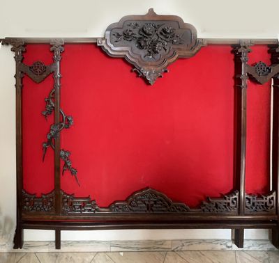 un mur rouge avec une tête de lit en bois et un mur rouge