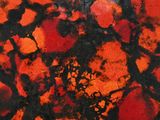 a close up of a red and black painting on a wall