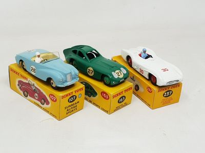 three toy cars are sitting on top of boxes on a white surface