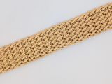 un gros plan d'un bracelet tressé posé sur une surface blanche