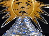 a glass sculpture of a sun with a face on it