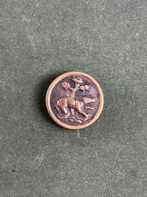 une image représentant un bouton en bronze orné d'un cerf