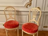 pair of chairs with red velvet upholstered seats in a white room