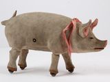 un petit cochon en peluche avec un ruban rose sur la tête