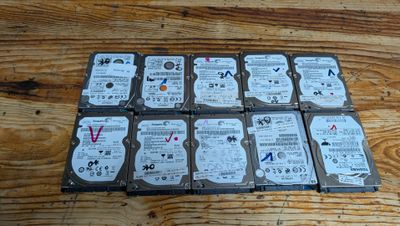 Plusieurs disques durs sont empilés les uns sur les autres sur une table en bois