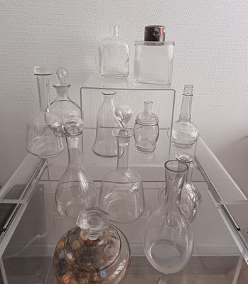 une table en verre sur laquelle sont posés de nombreux vases en verre