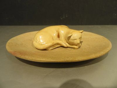 a yellow plate with a cat on it on a table
