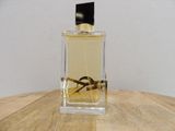 an image of a bottle of perfume sitting on top of a wooden table