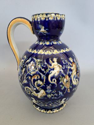 un vase bleu orné d'un motif doré et blanc