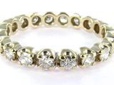 a yellow gold ring with diamonds on a white background