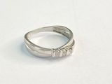 bague en argent ornée de trois pierres, posée sur une surface blanche