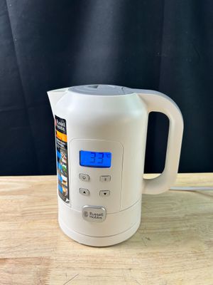 a white electric kettle sitting on a wooden table