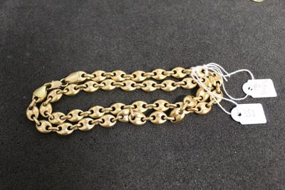 a close up of a gold chain bracelet on a black surface