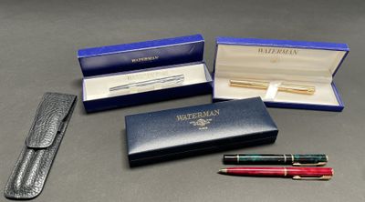 three pens and a pen in a case on a table