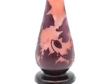a glass vase with a bird on it on a stand