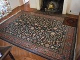 a living room with a fireplace and a rug on the floor