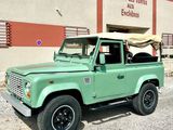 an image of a green land rover parked in front of a building