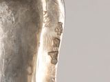 silver plated sculpture of a woman ' s head with a bird on her head