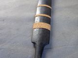 a long black and gold stick on a blue surface