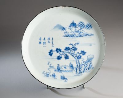 a blue and white plate with a landscape on it