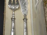 deux cuillères en argent et un couteau dans une boîte