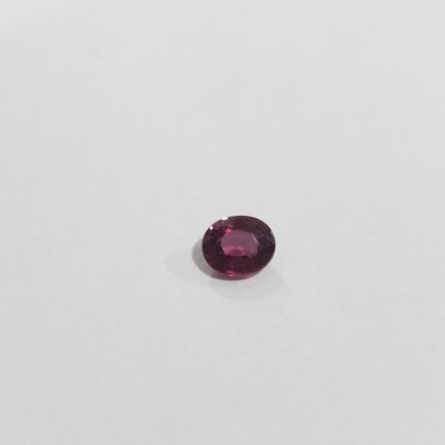 a round shaped pink sapphire stone on a white surface
