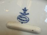 a person holding a white plate with a blue crown on it