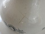 a white vase sitting on a table with a brown lid