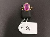 a close up of a pink stone ring on a black surface