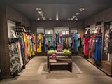 a photo of a clothing store with a lot of clothes on display