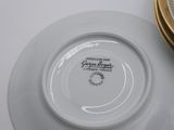 a white plate with a gold rim sitting on a table