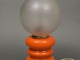 an orange and white table lamp with a glass ball on top of it