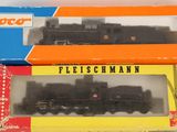 two boxed trains sitting on a table next to each other