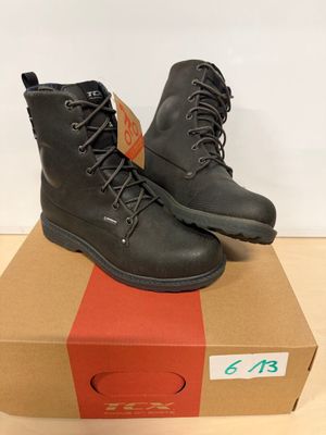 Il y a une paire de bottes noires posée sur la boîte.
