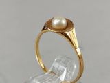 a close up of a gold ring with a pearl in it