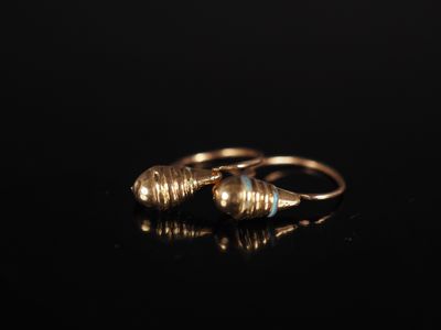 an image of a pair of gold earrings on a black surface
