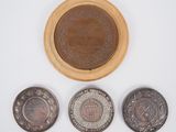 three coins and a wooden box with a plaque on it