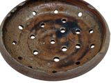 a rusted metal tray with holes in it