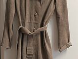 trench coat on a hanger in front of a door