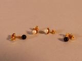 trois paires de boucles d'oreilles à clous en perles noires et blanches posées sur un fond blanc