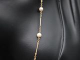 a close up of a mannequin wearing a necklace with pearls