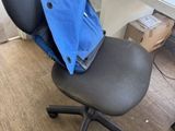 a black chair with a blue blanket on top of it