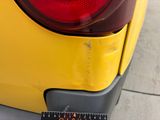 a close up of a yellow car with a measuring tape on it