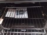 an open oven door with a metal rack in it