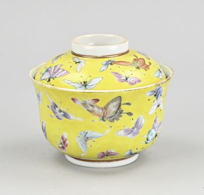 yellow and white porcelain jar with butterflies on it on a gray surface